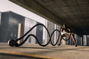 man exercising with battle ropes outdoors